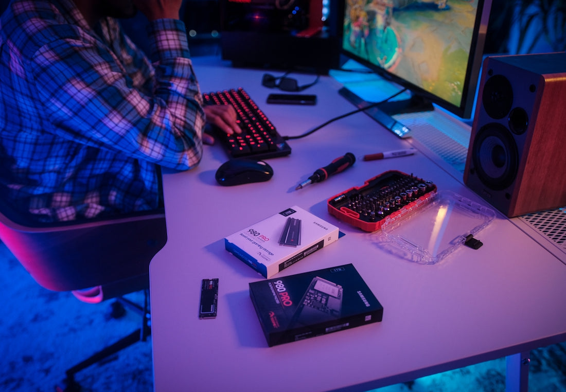 a person sitting at a desk with a computer and other electronics