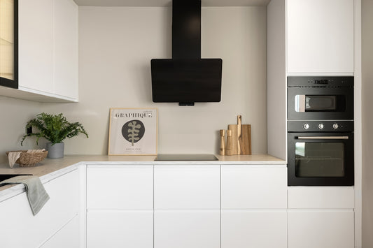 A kitchen with white cabinets and black appliances